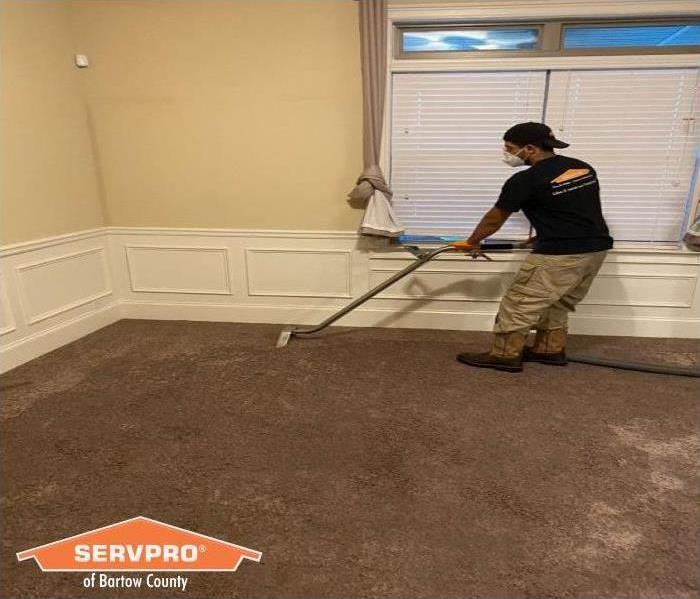 Extracting water from living room carpet at home that suffered a water damage